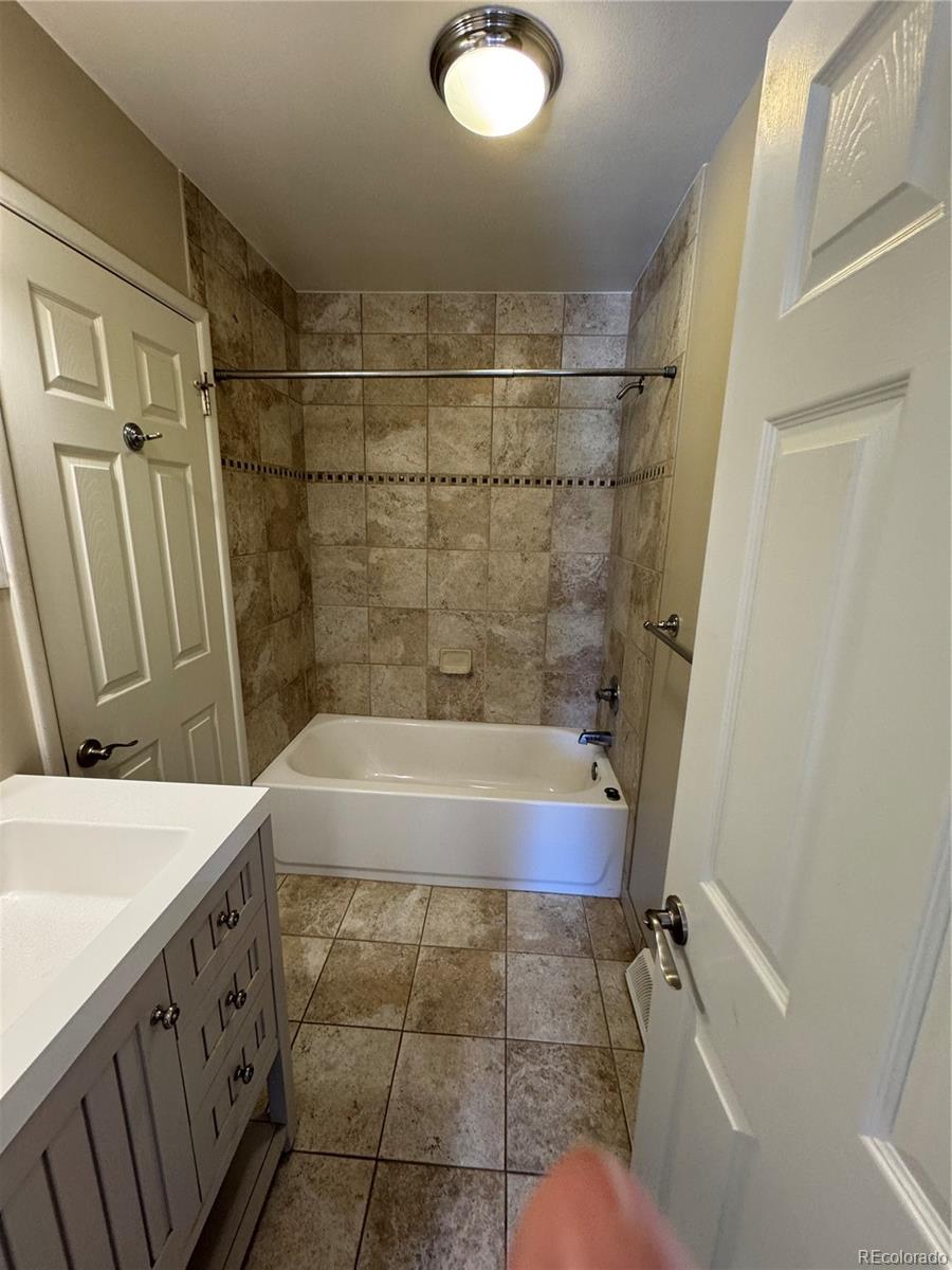 2524 South Oneida Street Denver, CO 80224 - Photo 9 of 11 a bathroom with a tub a sink and a shower