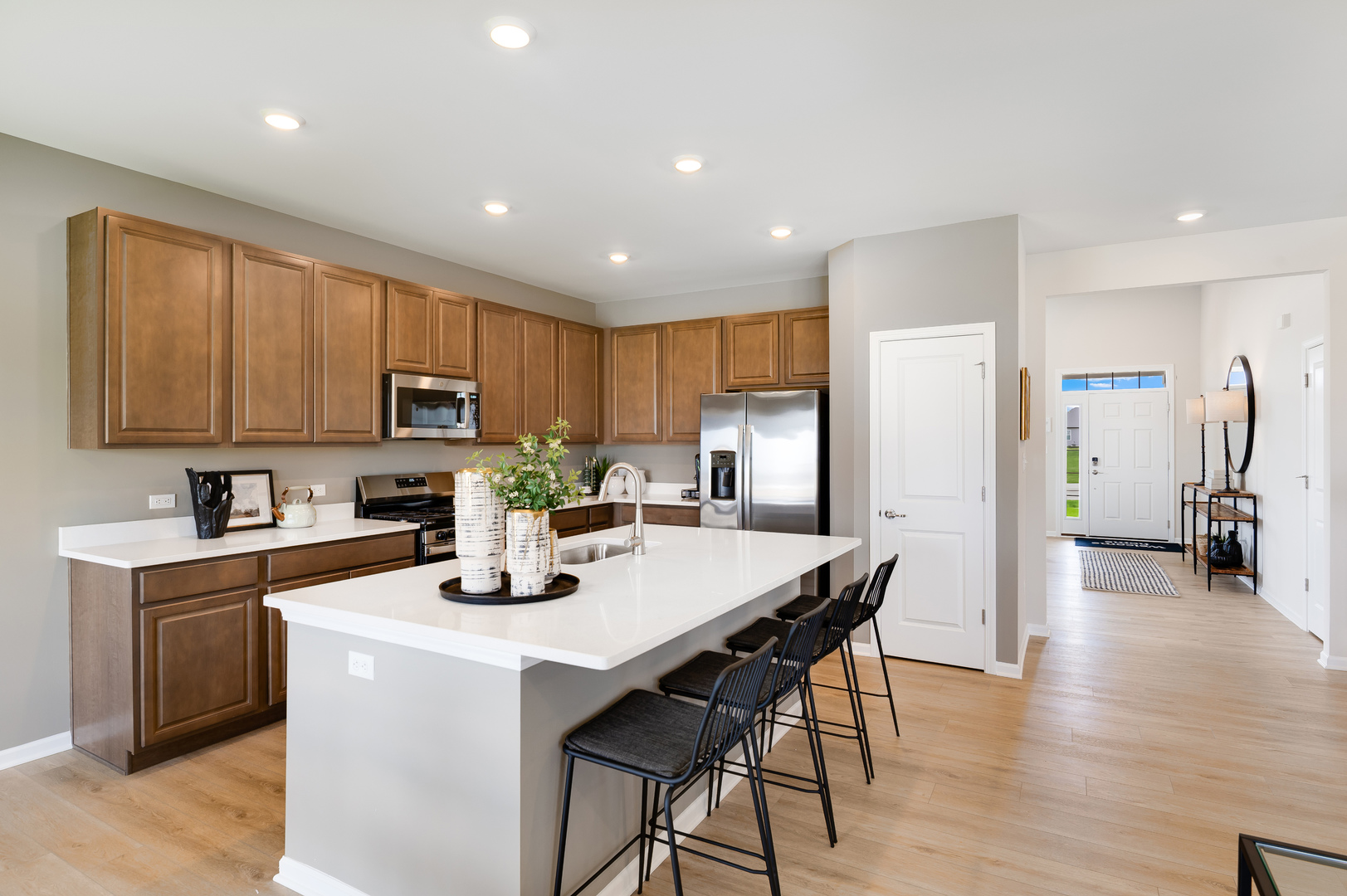 115 Henderson Street Oswego, IL 60543 - Photo 6 of 20 a kitchen with stainless steel appliances granite countertop a refrigerator a stove top oven a sink dishwasher and white cabinets with wooden floor