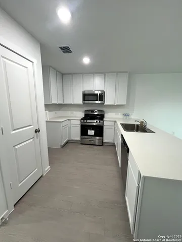 a kitchen with a sink a stove and cabinets