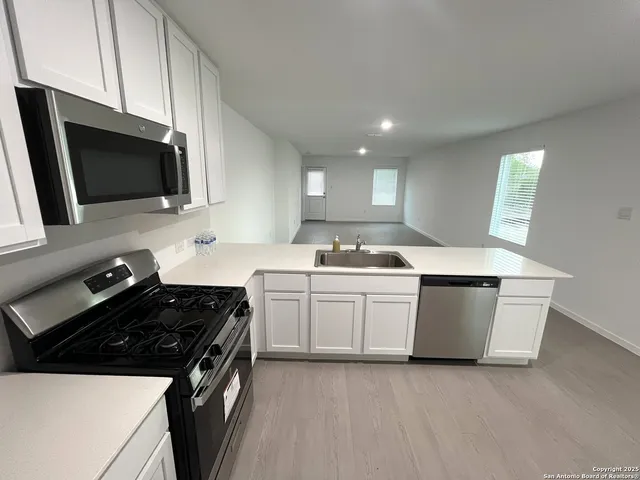 a view of a kitchen with a sink and cabinets