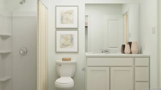 a bathroom with a toilet sink vanity and mirror