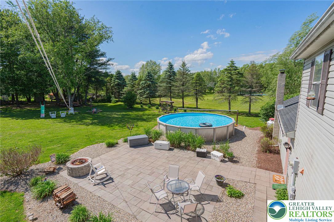 341 Lower Greenhill Road Kunkletown, PA 18058 - Photo 47 of 69 An inviting backyard oasis features a paved patio, a fire pit, and an above-ground pool.