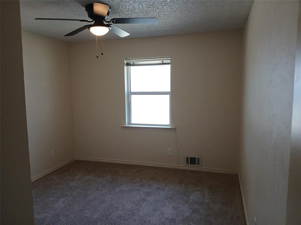 910 Worcester Lane Garland, TX 75040 - Photo 14 of 15 an empty room with a window and a fan
