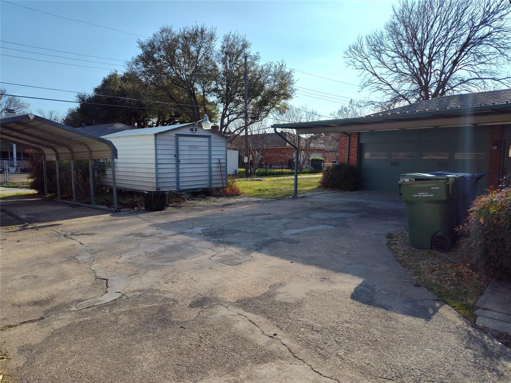910 Worcester Lane Garland, TX 75040 - Photo 15 of 15 a view of a backyard with large trees and a barn