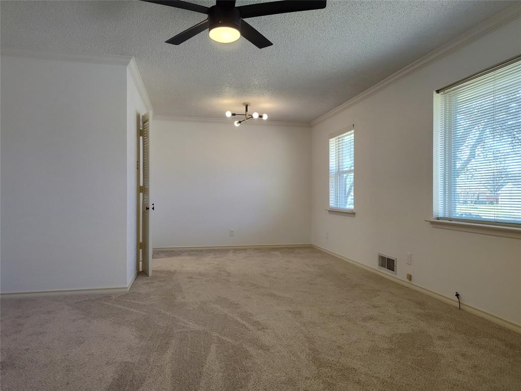 910 Worcester Lane Garland, TX 75040 - Photo 4 of 15 en empty room with windows and ceiling fan