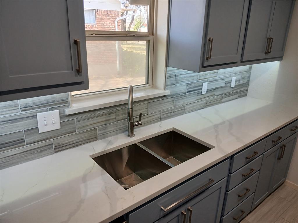 910 Worcester Lane Garland, TX 75040 - Photo 7 of 15 a kitchen with granite countertop white cabinets and a window