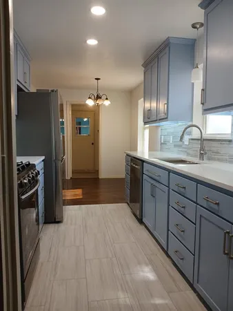 a kitchen with stainless steel appliances granite countertop a refrigerator and a sink