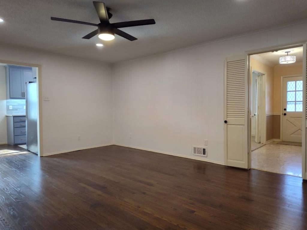 910 Worcester Lane Garland, TX 75040 - Photo 9 of 15 an empty room with wooden floor chandelier fan and windows