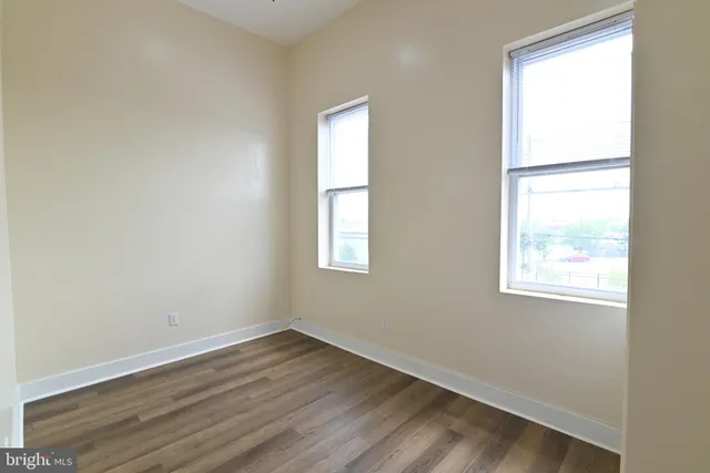 an empty room with wooden floor and a window