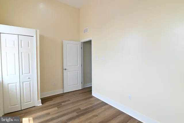 a view of an empty room with wooden floor