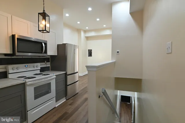 a kitchen with stainless steel appliances a stove microwave and refrigerator