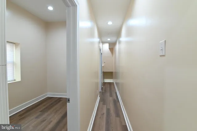 a view of a hallway with wooden floor and staircase