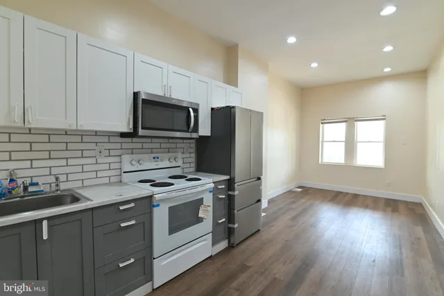 a kitchen with stainless steel appliances granite countertop a stove a sink and a refrigerator
