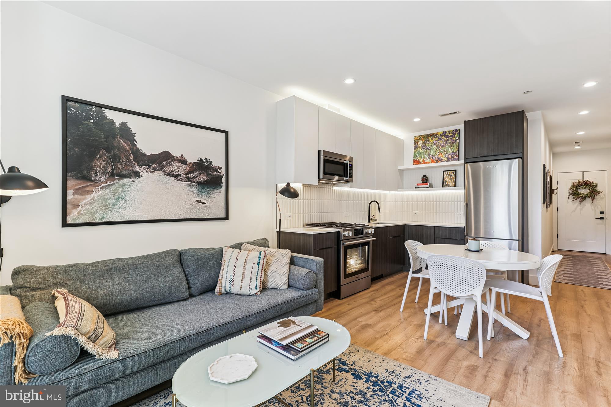 a living room with furniture kitchen view and a refrigerator