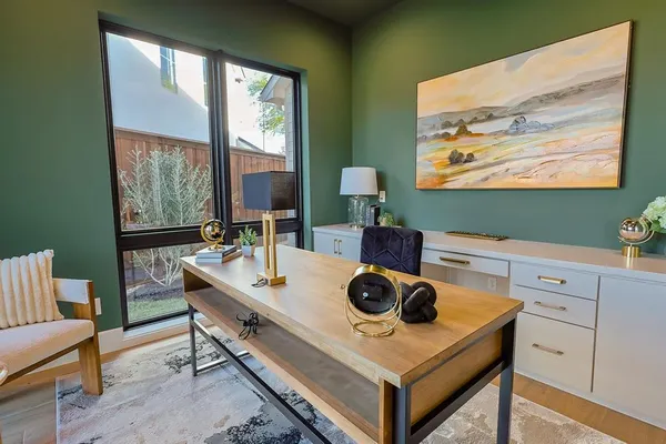 a view of a hallway with wooden floor and a kitchen