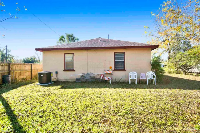 a view of a house with backyard and sitting area
