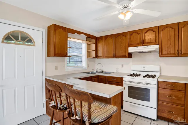 a kitchen with a stove a sink and cabinets