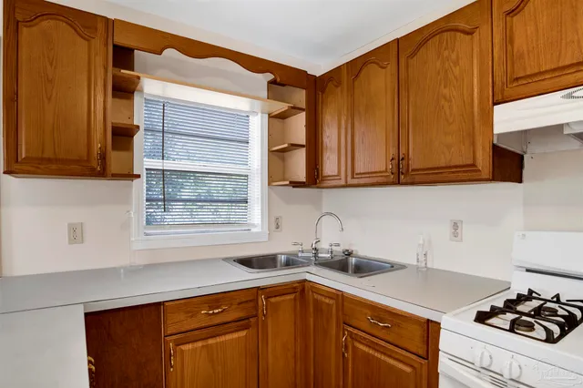 a kitchen with stainless steel appliances granite countertop a sink stove and cabinets