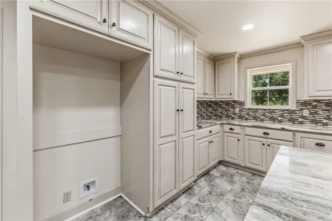a kitchen with white cabinets and white appliances