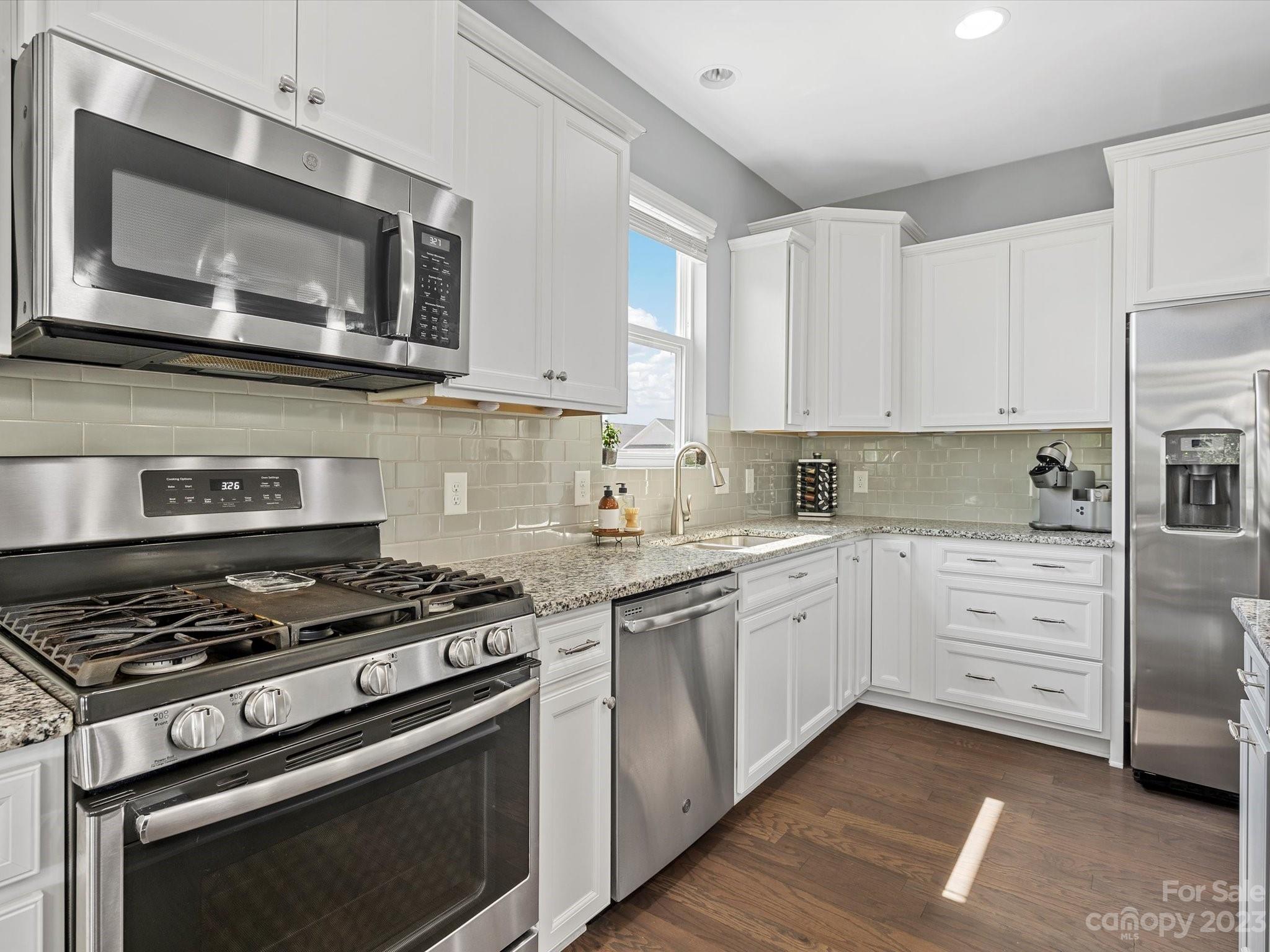 3187 Bridgewater Street Lancaster, SC 29720 - Photo 14 of 37 a kitchen with stainless steel appliances granite countertop a stove top oven microwave and cabinets