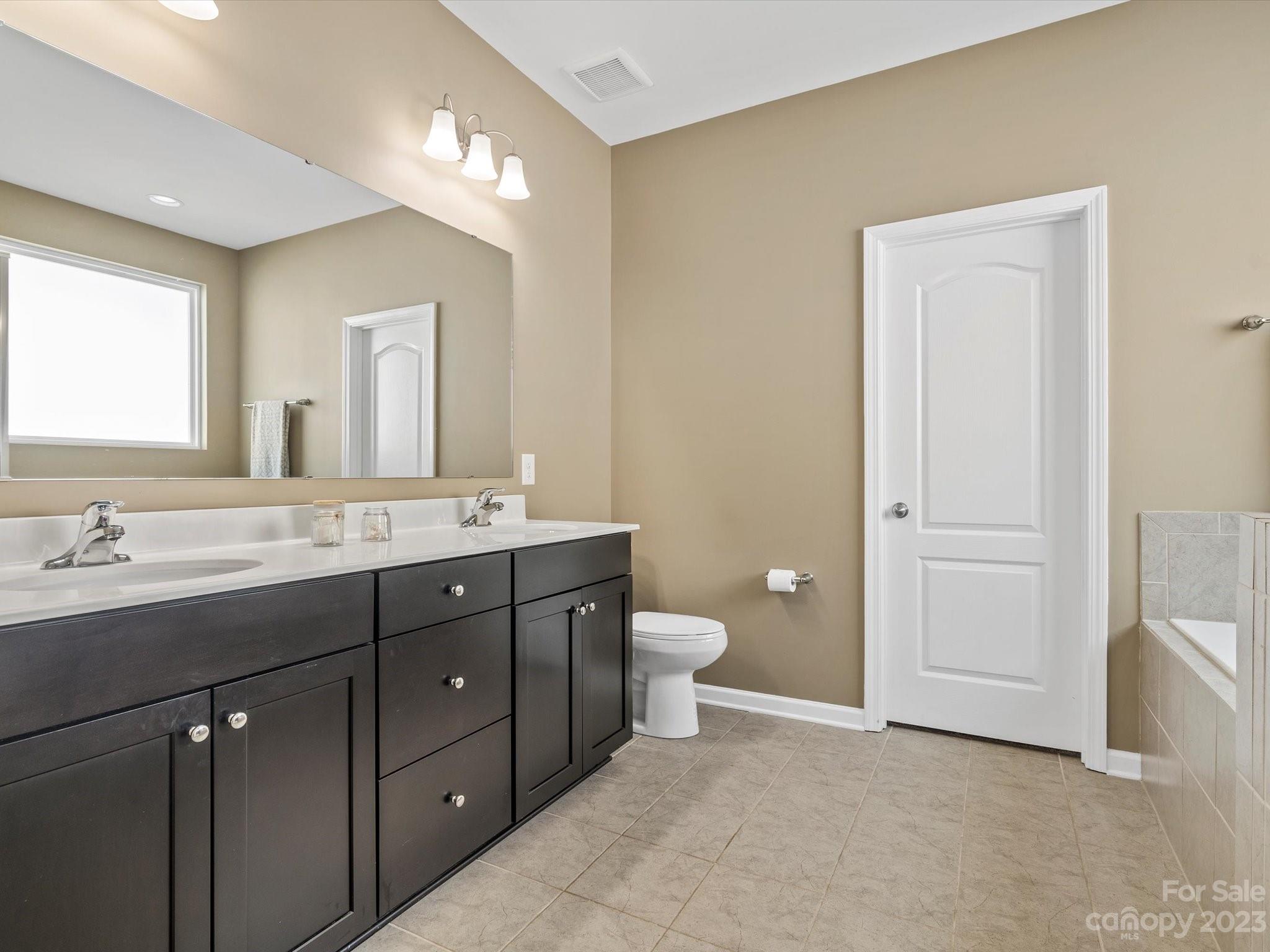 3187 Bridgewater Street Lancaster, SC 29720 - Photo 23 of 37 a spacious bathroom with a double vanity sink a toilet and a mirror