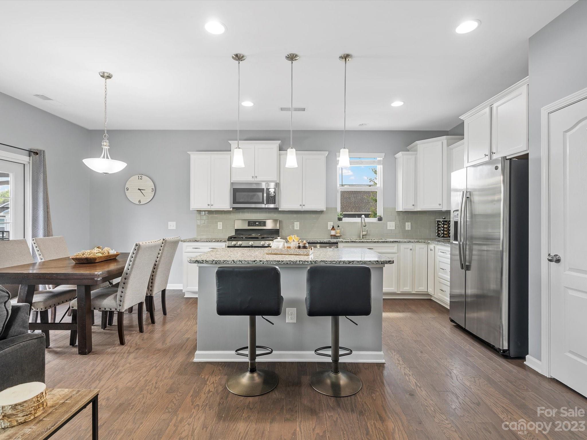 3187 Bridgewater Street Lancaster, SC 29720 - Photo 9 of 37 a kitchen with stainless steel appliances granite countertop a sink a stove a refrigerator cabinets dining table and chairs
