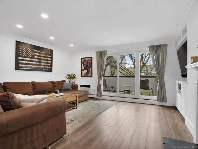 a living room with furniture and a large window with wooden floor