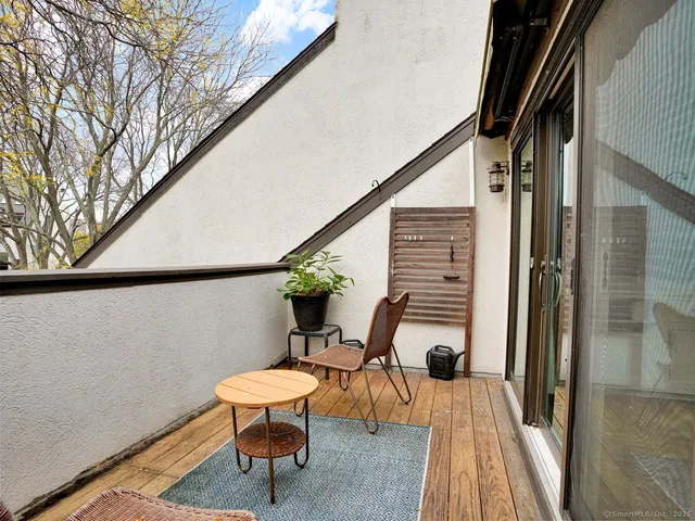 a balcony with chairs and wooden floor