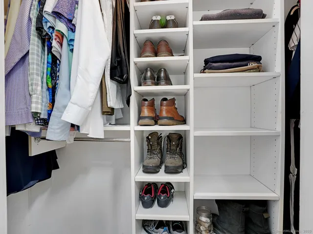 a view of walk in closet with clothes and shoes
