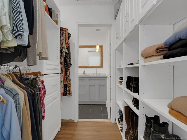 a view of walk in closet with clothes and shoes