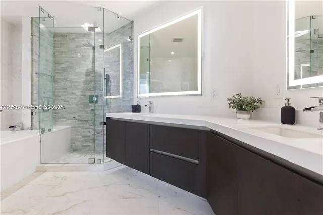 a bathroom with a sink a large mirror and a shower