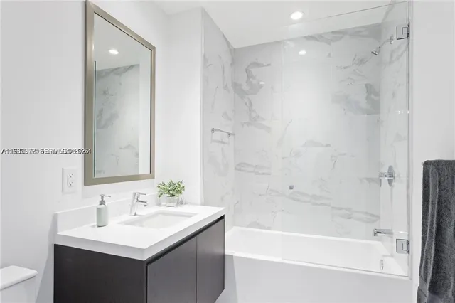 a bathroom with a bathtub shower sink and a toilet