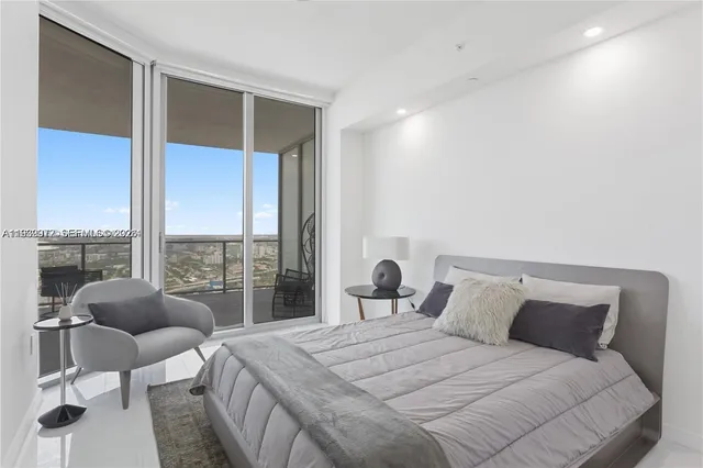 a bedroom with a bed and a large window