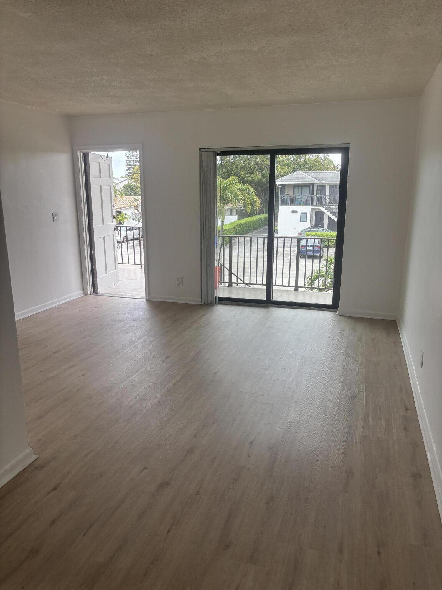521 Northeast 45th Street Boca Raton, FL 33431 - Photo 3 of 17 a view of an empty room with wooden floor and a window