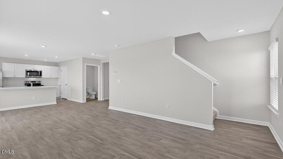 3613 Turney Drive Raleigh, NC 27610 - Photo 15 of 39 a view of empty room with wooden floor and kitchen