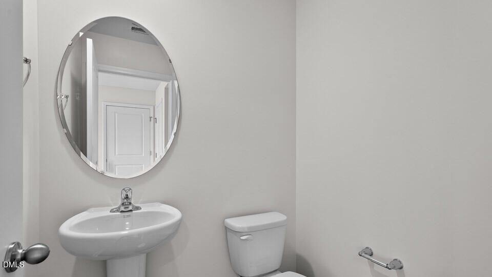 3613 Turney Drive Raleigh, NC 27610 - Photo 17 of 39 a bathroom with a toilet sink and mirror