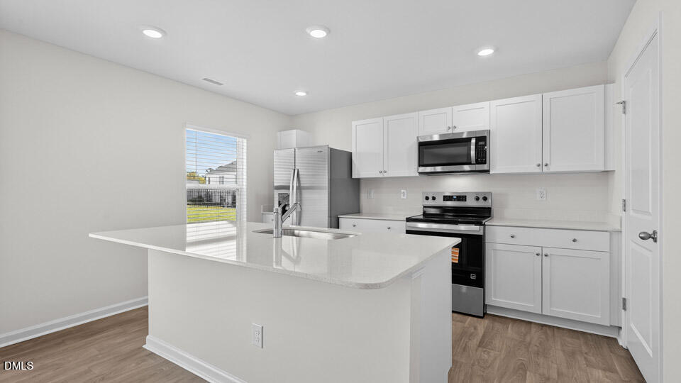3613 Turney Drive Raleigh, NC 27610 - Photo 8 of 39 a kitchen with stainless steel appliances white cabinets and a refrigerator
