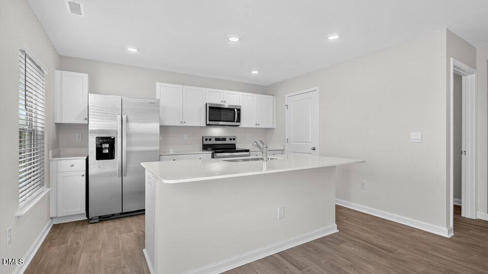 3613 Turney Drive Raleigh, NC 27610 - Photo 10 of 39 a kitchen with cabinets stainless steel appliances and wooden floor