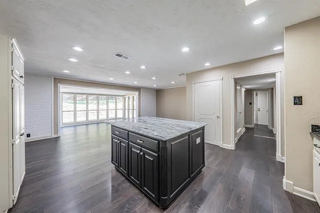 a kitchen with a stove and wooden floor