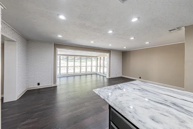 an empty room with wooden floor and window