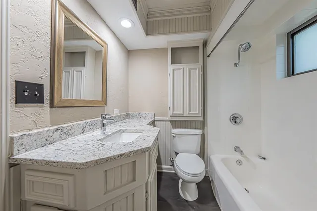 a bathroom with a granite countertop sink toilet and shower