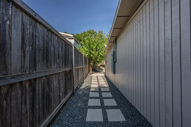 a view of a pathway with wooden fence