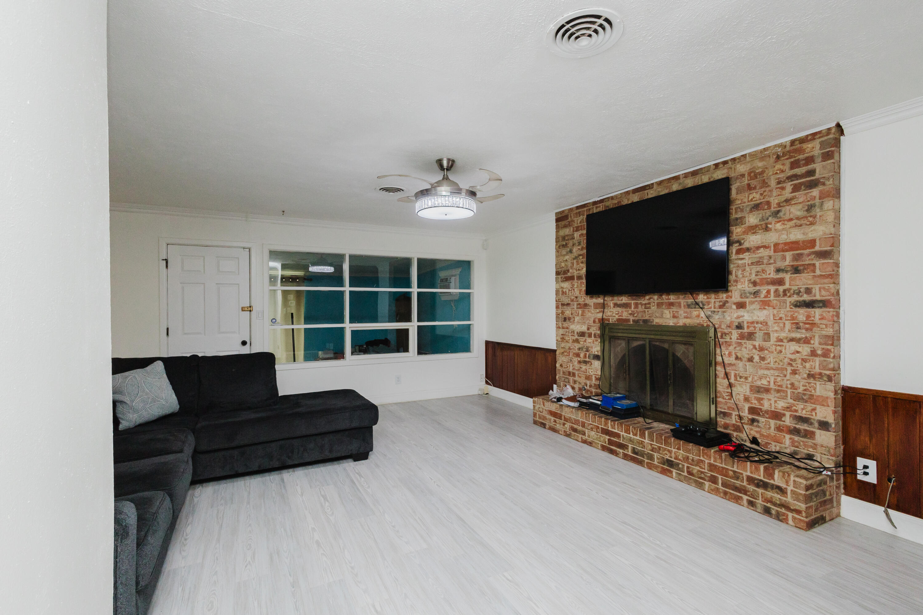 2110 57th Street Lubbock, TX 79412 - Photo 12 of 49 a living room with furniture a fireplace and a flat screen tv