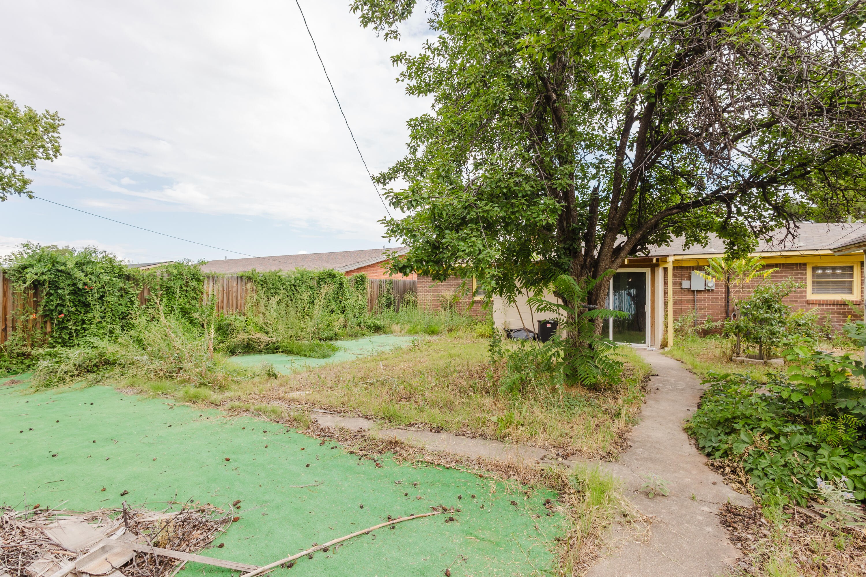 2110 57th Street Lubbock, TX 79412 - Photo 47 of 49 a backyard of a house with a garden and plants