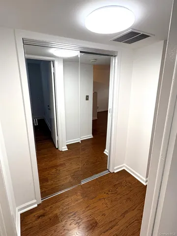 a view of a room with wooden floor and white walls