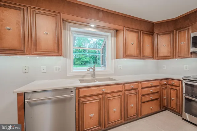a kitchen with stainless steel appliances granite countertop a sink dishwasher and cabinets with wooden floor