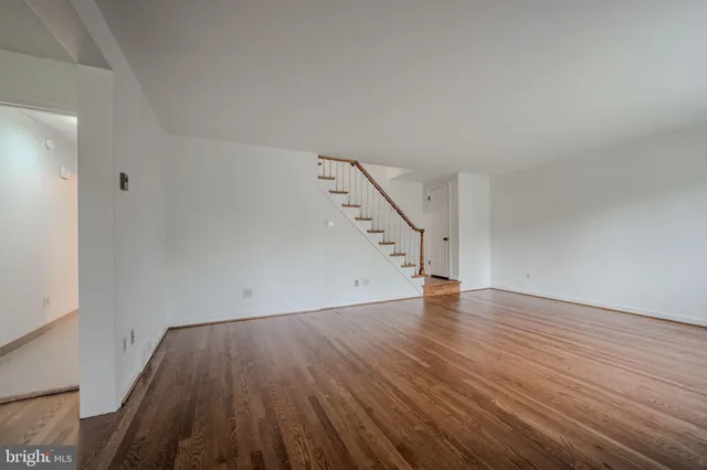 an empty room with wooden floor and white walls