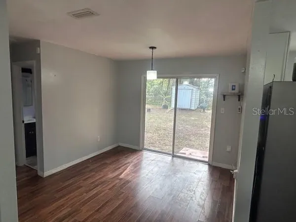 an empty room with wooden floor and a window