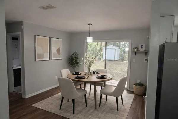 a dining room with furniture a chandelier and wooden floor