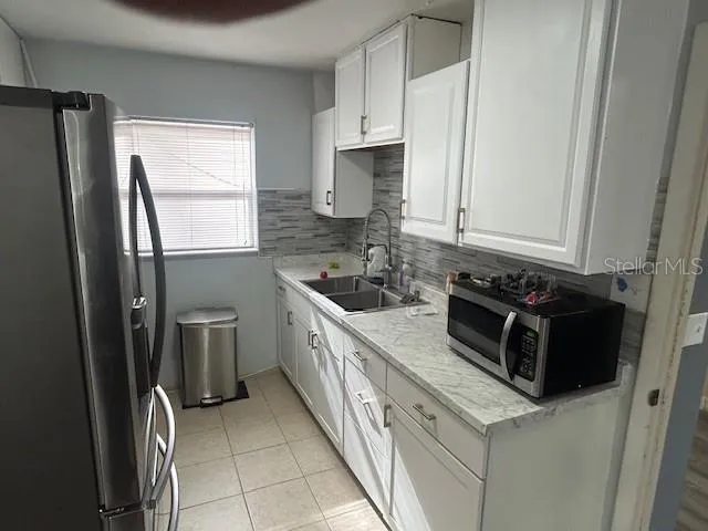 a kitchen with stainless steel appliances a refrigerator sink and stove